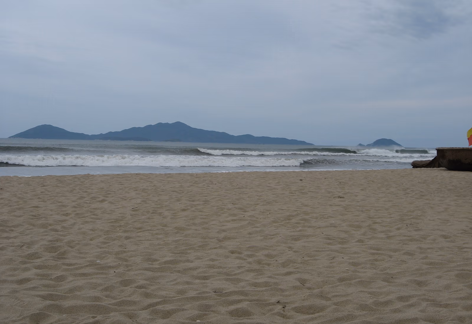 Plage de sable face aux reliefs boisés de l’archipel de Cù Lao Chàm