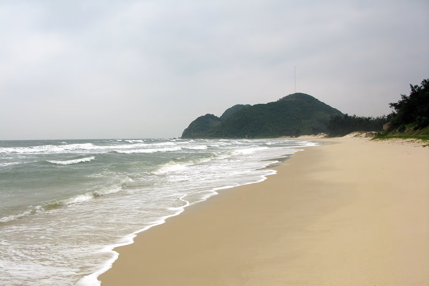 Plage de Sơn Hào, mer claire et collines boisées sur l’île de Quan Lạn