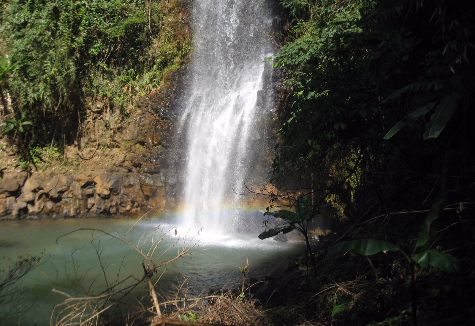 Cascade et bassin entourés de forêt à Măng Đen
